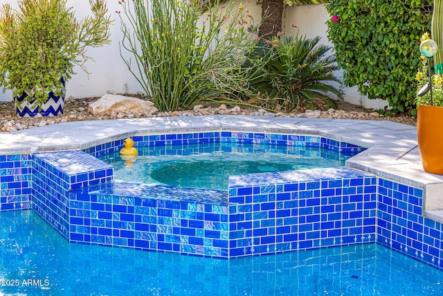 view of pool featuring an in-ground hot tub