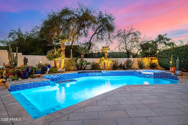 view of swimming pool with a pool with connected hot tub, a fenced backyard, and a patio area
