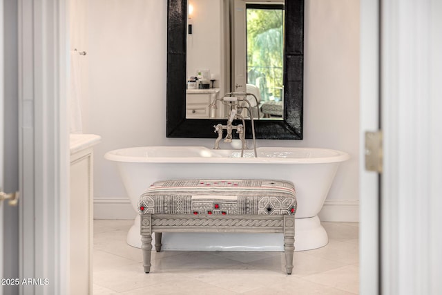 full bath featuring baseboards, a soaking tub, and tile patterned flooring
