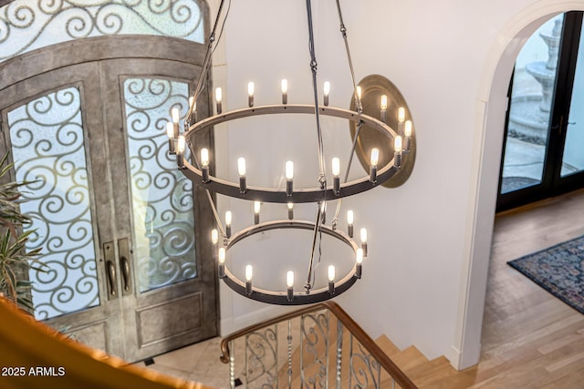 detailed view of french doors, a chandelier, and arched walkways