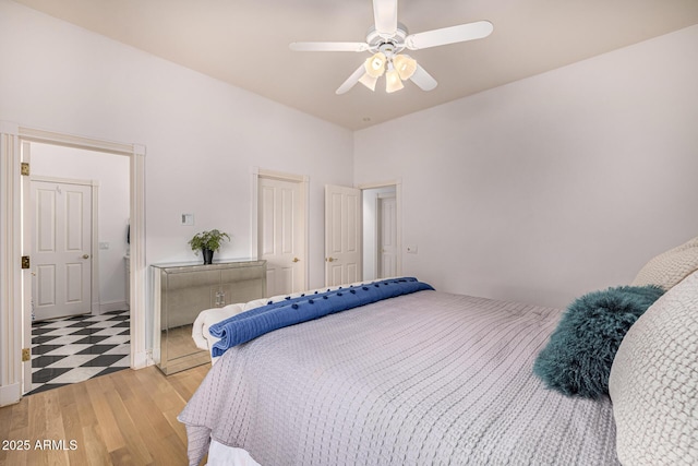 bedroom with light wood finished floors, ceiling fan, and a closet
