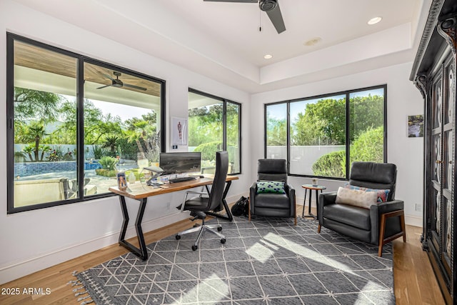 office with a ceiling fan, dark wood-style flooring, a tray ceiling, baseboards, and recessed lighting