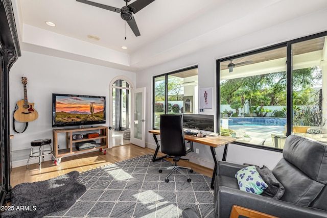 office with a ceiling fan, wood finished floors, baseboards, a raised ceiling, and recessed lighting