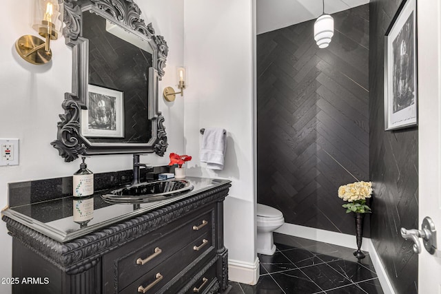 bathroom with baseboards, toilet, and vanity