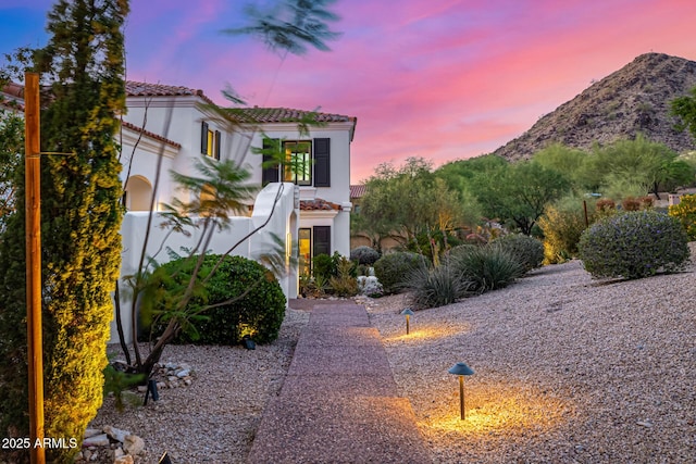 view of front of home with a tiled roof, stucco siding, and a mountain view