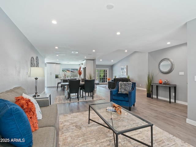 living room with vaulted ceiling and light hardwood / wood-style floors