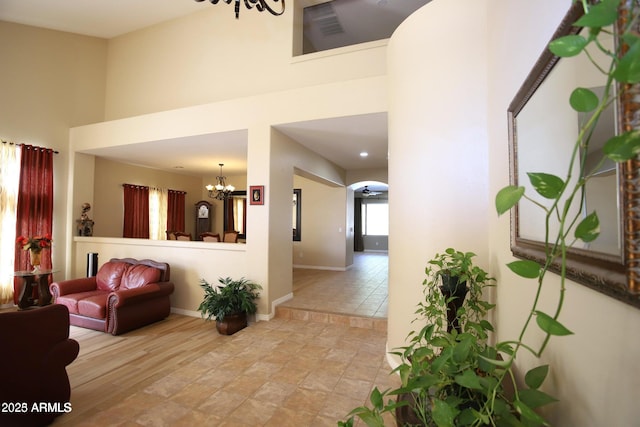 interior space with a high ceiling, a chandelier, and baseboards