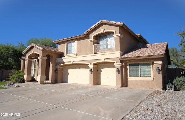 mediterranean / spanish-style house featuring a tiled roof, stucco siding, a balcony, a garage, and driveway