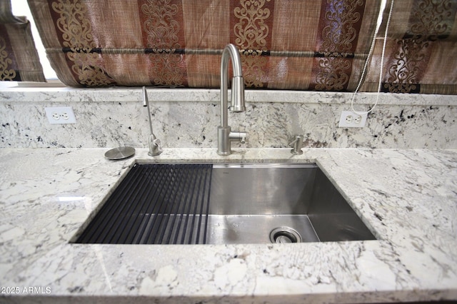 interior details with tasteful backsplash, light stone counters, and a sink