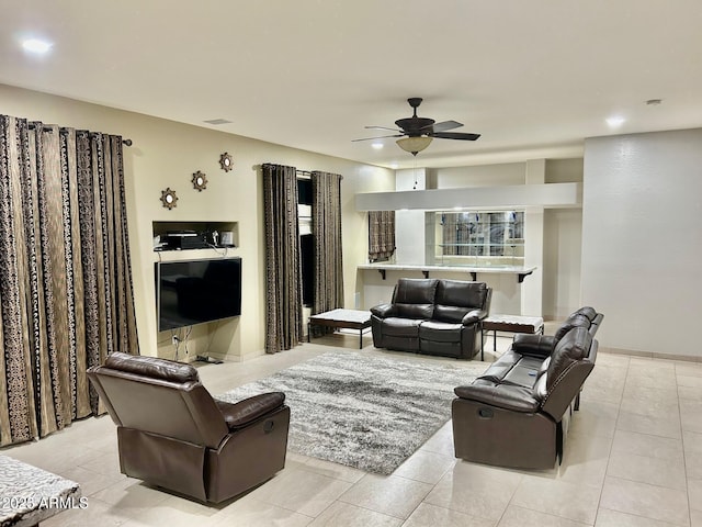 living area with light tile patterned floors, ceiling fan, and visible vents