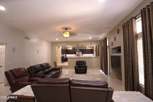 living room with light tile patterned floors, visible vents, and a ceiling fan