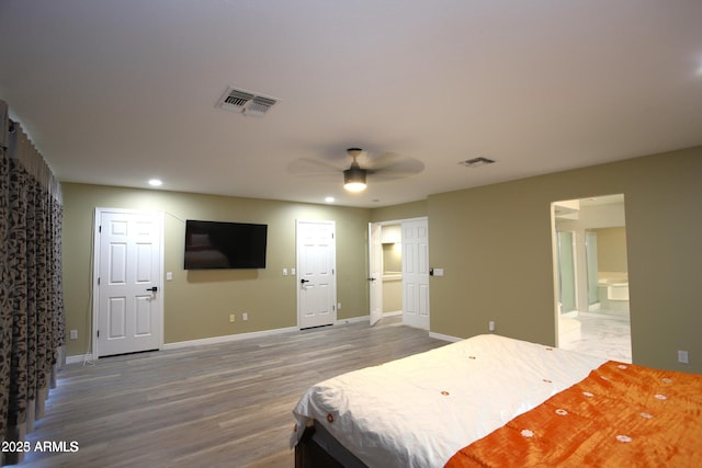 bedroom with visible vents, baseboards, and wood finished floors