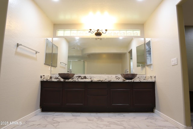 full bath featuring marble finish floor, a sink, and baseboards