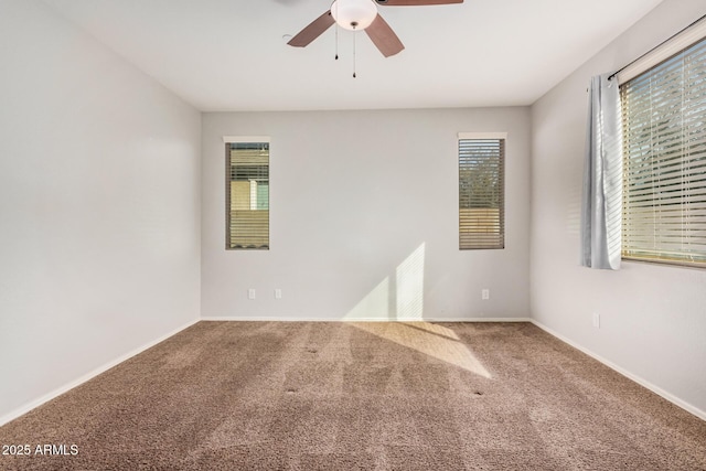 empty room featuring ceiling fan, carpet flooring, and baseboards
