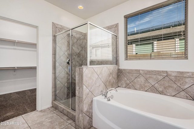 full bathroom with a shower stall, a walk in closet, and plenty of natural light