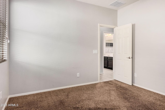 spare room with light colored carpet and baseboards