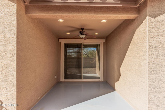 property entrance with stucco siding and ceiling fan