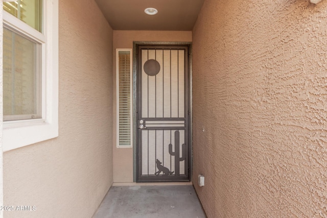 entrance to property featuring stucco siding