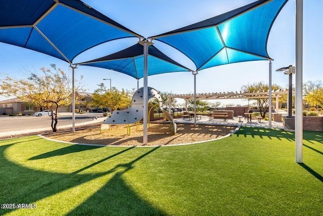 view of playground with a pergola and a lawn