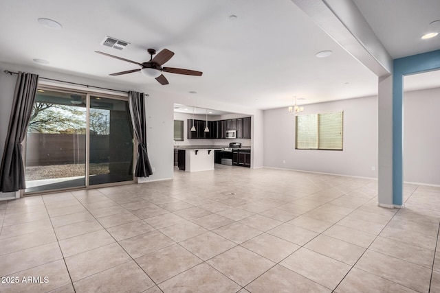 unfurnished living room with light tile patterned floors, a chandelier, ceiling fan, baseboards, and recessed lighting