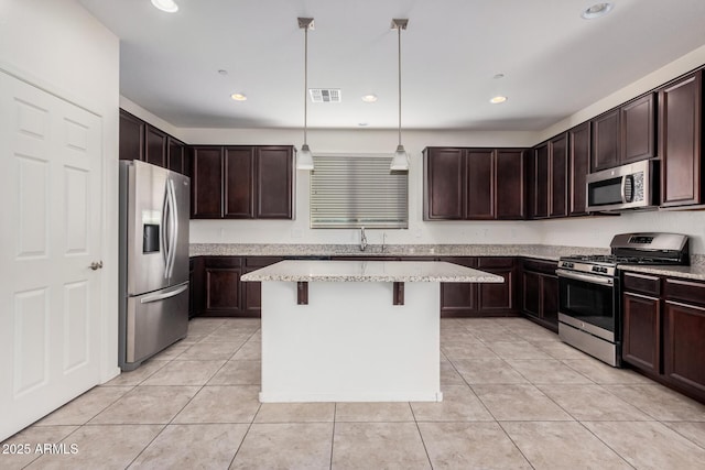 kitchen with stainless steel appliances, light tile patterned floors, dark brown cabinetry, a breakfast bar, and recessed lighting