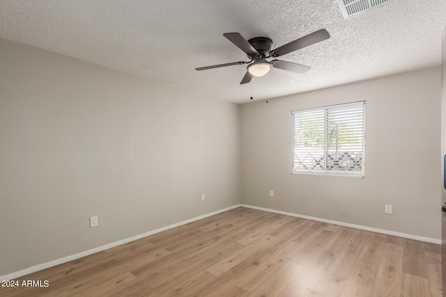 empty room with ceiling fan, a textured ceiling, and light wood-type flooring