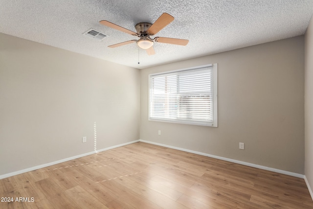 empty room with ceiling fan, a textured ceiling, and light wood-type flooring