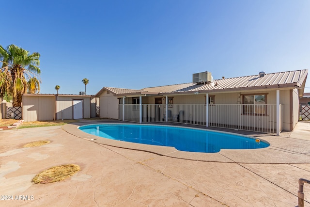 view of swimming pool with central AC unit and a patio area