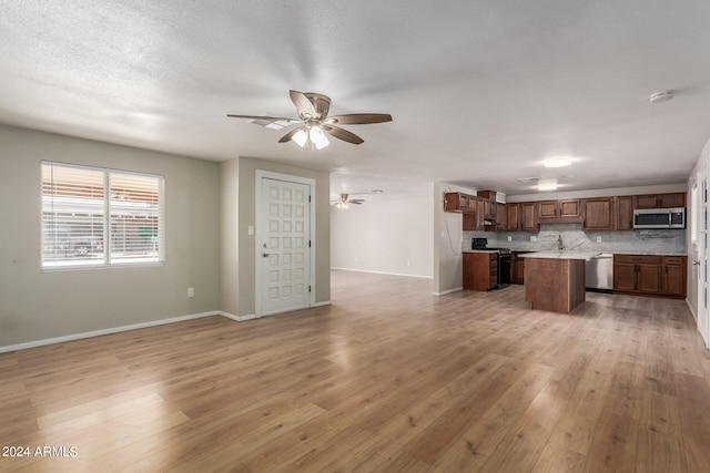 kitchen featuring light hardwood / wood-style flooring, stainless steel appliances, backsplash, and a center island