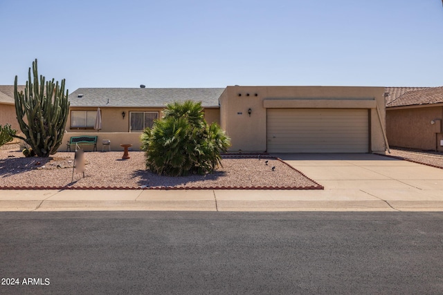 southwest-style home with stucco siding, a garage, and concrete driveway