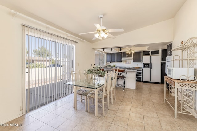 dining space featuring light tile patterned flooring, lofted ceiling, and a ceiling fan