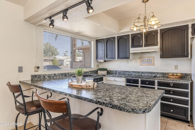 kitchen with rail lighting, a breakfast bar, kitchen peninsula, white dishwasher, and decorative light fixtures