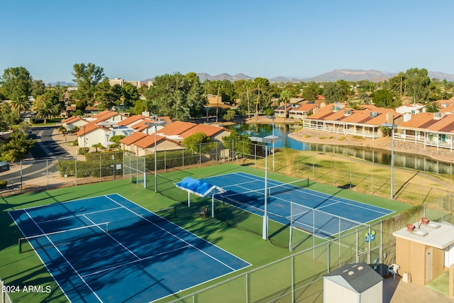 view of sport court featuring a residential view, a mountain view, and fence