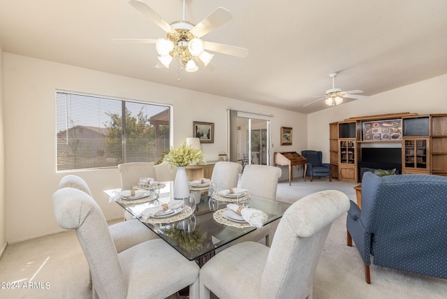 carpeted dining room featuring lofted ceiling and ceiling fan