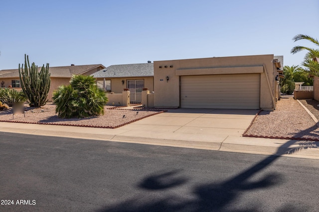 pueblo-style home featuring concrete driveway, stucco siding, and an attached garage
