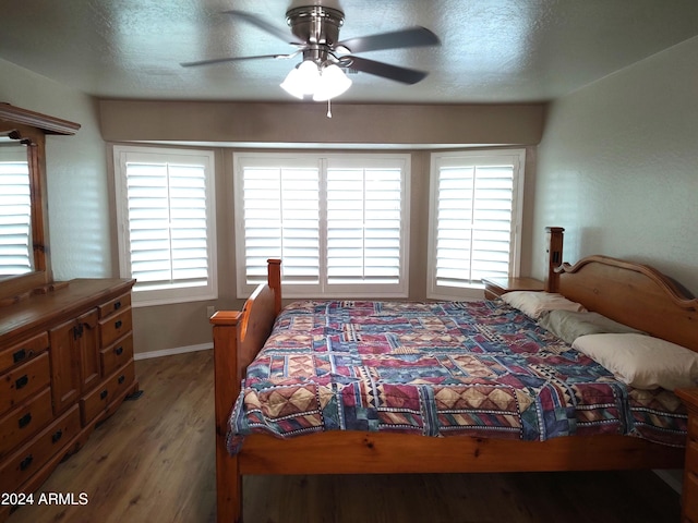 bedroom featuring multiple windows, hardwood / wood-style floors, and ceiling fan