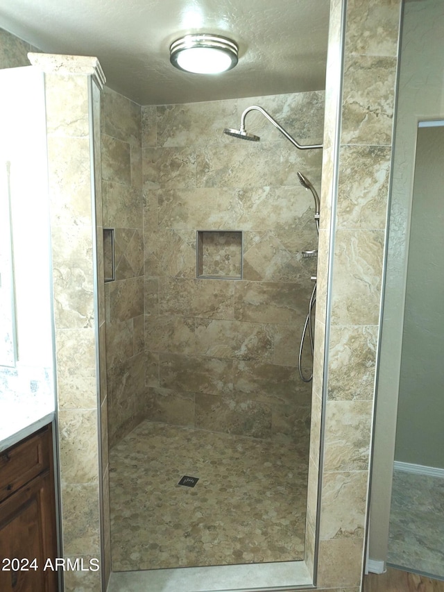 bathroom featuring a tile shower and vanity