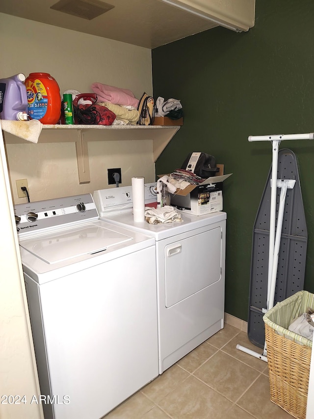 laundry area featuring light tile patterned floors and washing machine and dryer