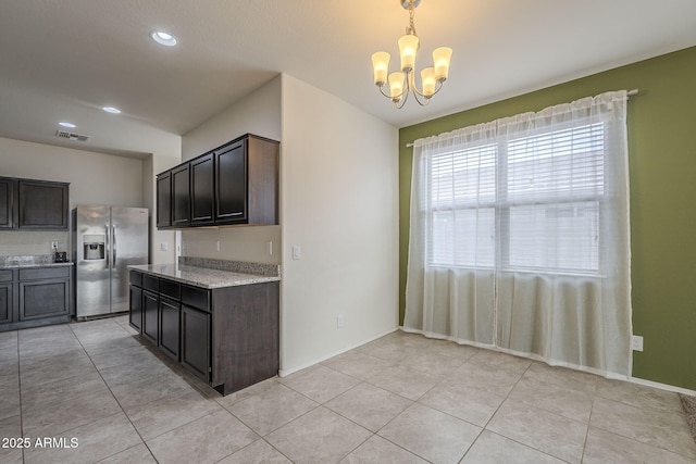 kitchen with a chandelier, pendant lighting, dark brown cabinetry, and stainless steel fridge with ice dispenser