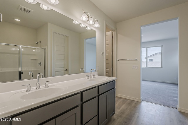 40030 W Bunker Dr, Maricopa, AZ 85138 - full bathroom with a shower with door, visible vents, a sink, and wood finished floors