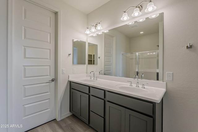 40030 W Bunker Dr, Maricopa, AZ 85138 - bathroom with a sink, a shower stall, double vanity, and wood finished floors