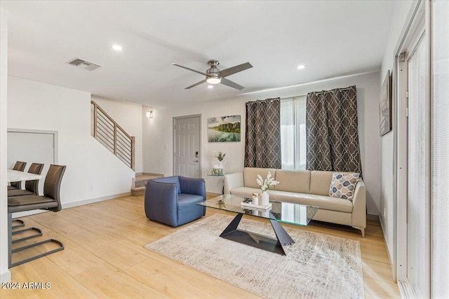 living room featuring ceiling fan and light hardwood / wood-style floors