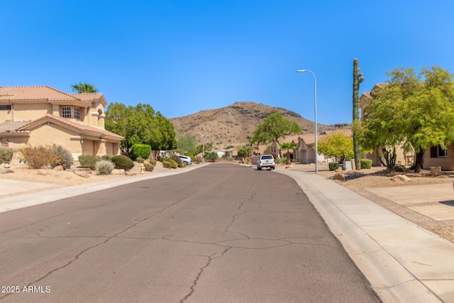 1211 E Desert Flower Ln, Phoenix, AZ 85048 - view of asphalt road featuring street lighting, a mountain view, sidewalks, and curbs