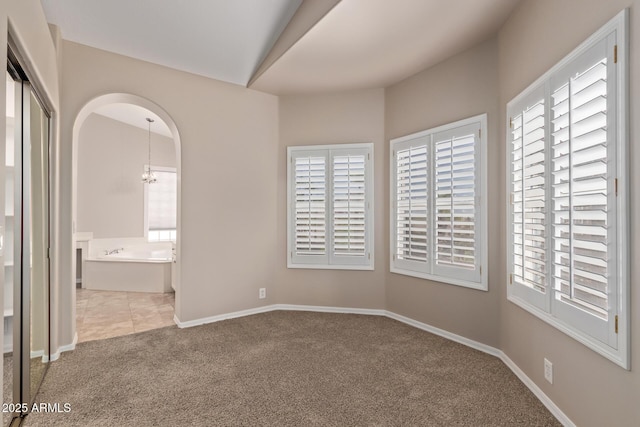 1211 E Desert Flower Ln, Phoenix, AZ 85048 - empty room with carpet floors, a chandelier, and arched walkways