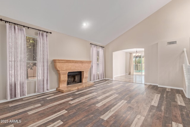 1211 E Desert Flower Ln, Phoenix, AZ 85048 - unfurnished living room with a chandelier, plenty of natural light, wood finished floors, a fireplace with raised hearth, and high vaulted ceiling