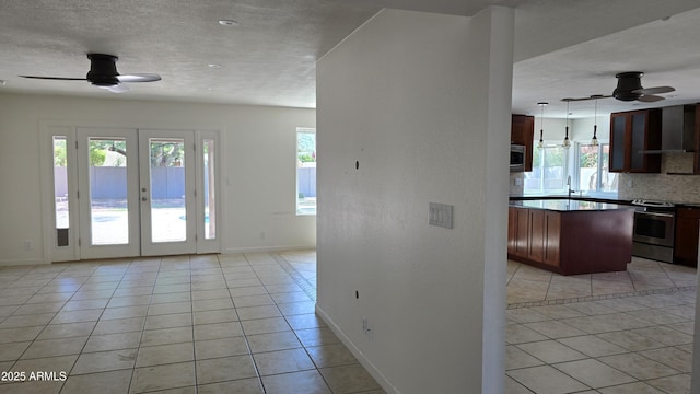 10232 N 86th St, Scottsdale, AZ 85258 - interior space featuring ceiling fan, wall chimney range hood, light tile patterned floors, and a textured ceiling