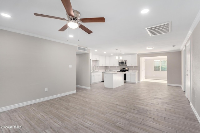 unfurnished living room featuring ceiling fan, light hardwood / wood-style floors, ornamental molding, and sink