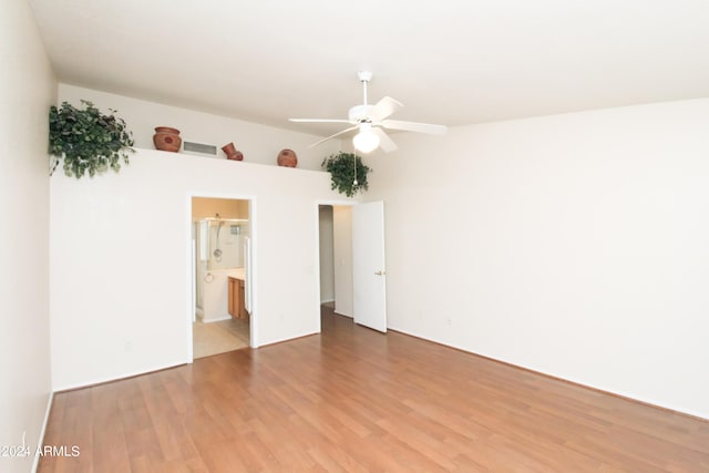 unfurnished bedroom featuring connected bathroom, light tile patterned floors, and ceiling fan