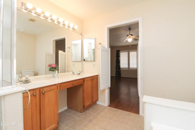 bathroom featuring dual bowl vanity, toilet, tile patterned floors, and ceiling fan