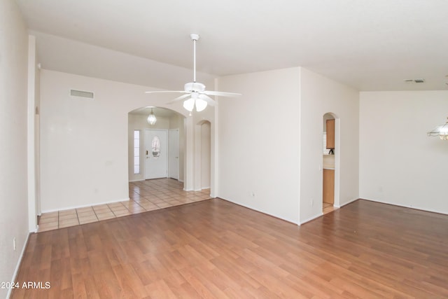 empty room with ceiling fan and light hardwood / wood-style flooring